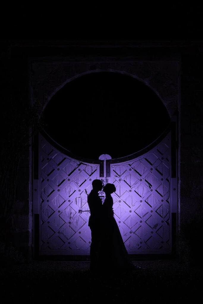 Les mariés en ombre et lumière devant le portail du Manoir de Vacheresse