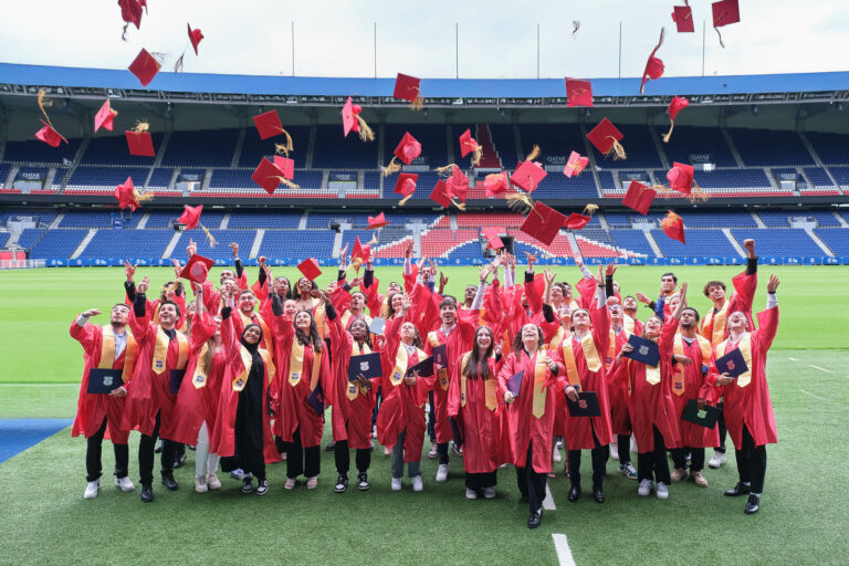 Groupe d'étudiants lançant leur chapeau en l'air après la cérémonie de remise de diplôme
